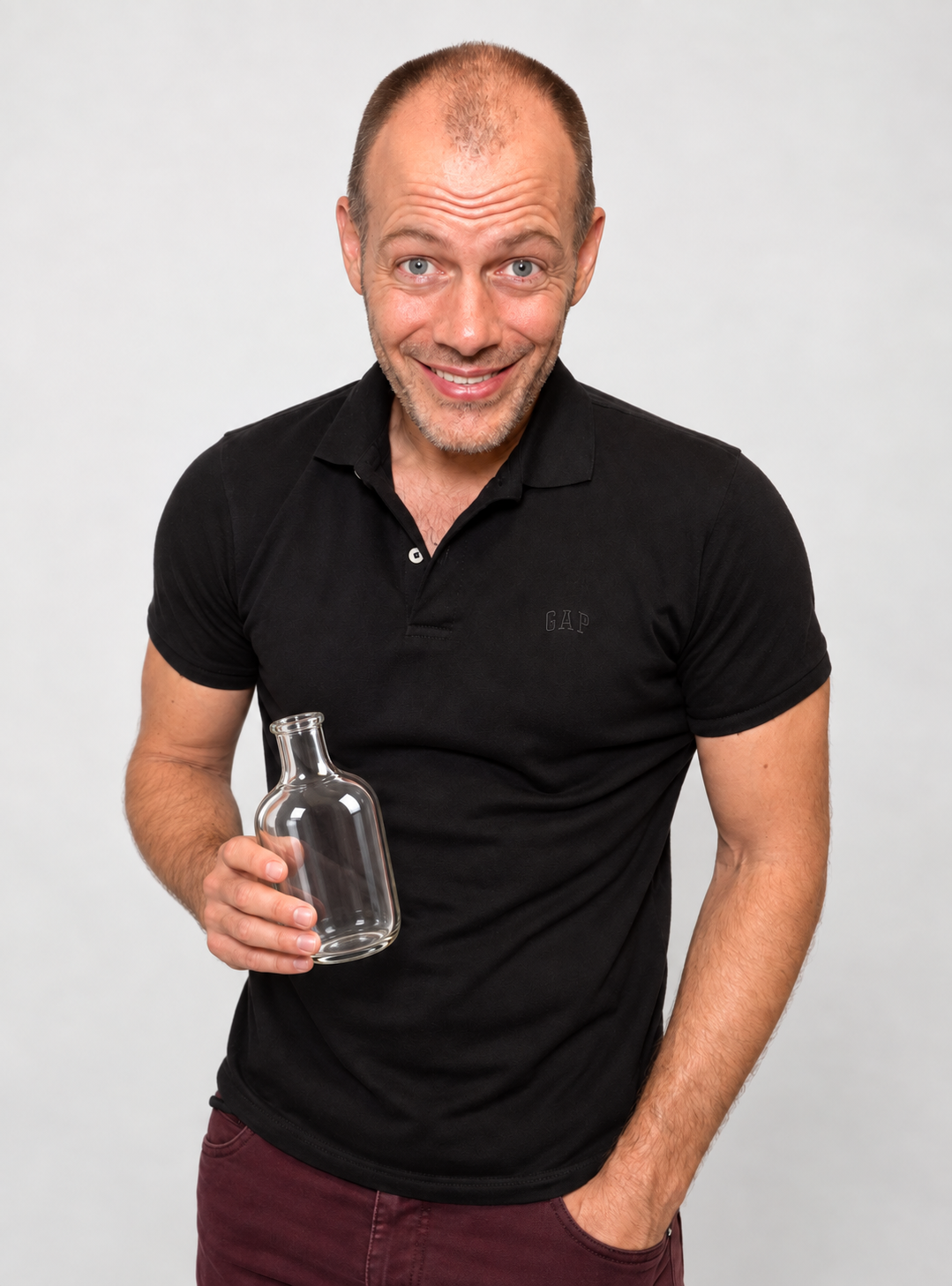 Alexandre Ouellet smiling while holding an empty glass bottle